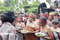 Para perempuan peserta aksi damai mengenakan pakaian adat sambil membawa piring berisi pinang dalam aksi damai di depan kantor KPU Papua Barat Daya, Kota Sorong, Senin (9/9/2024). (FOTO: TRIBUNSORONG)