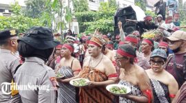 Para perempuan peserta aksi damai mengenakan pakaian adat sambil membawa piring berisi pinang dalam aksi damai di depan kantor KPU Papua Barat Daya, Kota Sorong, Senin (9/9/2024). (FOTO: TRIBUNSORONG)