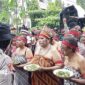 Para perempuan peserta aksi damai mengenakan pakaian adat sambil membawa piring berisi pinang dalam aksi damai di depan kantor KPU Papua Barat Daya, Kota Sorong, Senin (9/9/2024). (FOTO: TRIBUNSORONG)