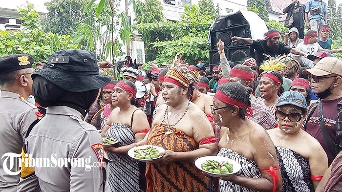 Para perempuan peserta aksi damai mengenakan pakaian adat sambil membawa piring berisi pinang dalam aksi damai di depan kantor KPU Papua Barat Daya, Kota Sorong, Senin (9/9/2024). (FOTO: TRIBUNSORONG)