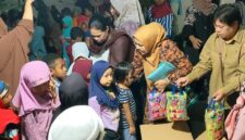 Nurwidayati Samaun Dahlan (jilbab coklat muda) dan Sri Voni Donatus Nimbitkendik (jilbab coklat tua) membagikan bingkisan kasih kepada anak-anak yatim saat buka puasa bersama di kediaman pribadi Bupati Samaun Dahlan, Jumat petang (14/3/2025). (Detik Indonesia/Tribun Papua Barat/Aldi Bimantara)