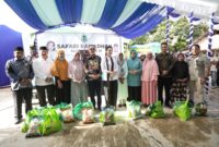 Gubernur Malut, Sherly Laos didampingi Bupati James Uang, dan Kadis Perindag dan Pangan, foto dengan warga yang menerima paket sembako secara simbolis, Kamis (13/3/2025).(Detik Indonesia/RRI/Yudi).